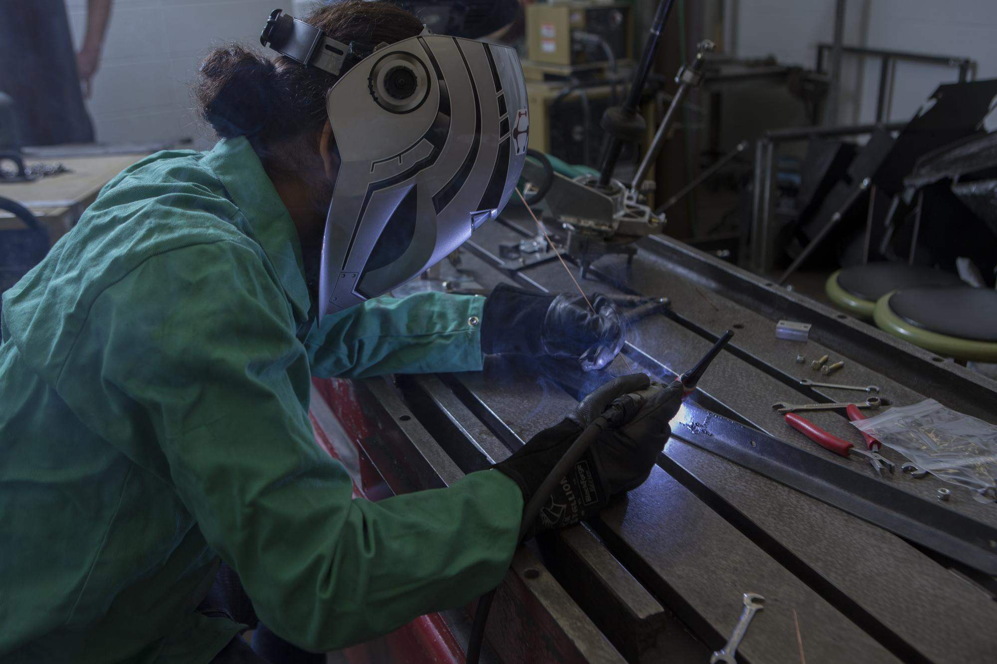 Engineering student welds together a project while on co-op
