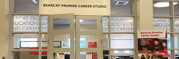 Glass front entrance with overhead sign saying "Bearcat Promise Career Studio"