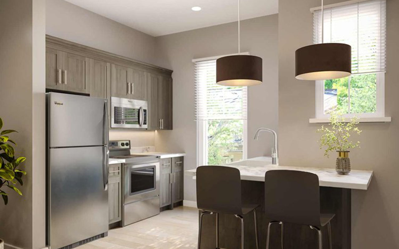 Kitchen features stainless steel appliances and seating at counter.
