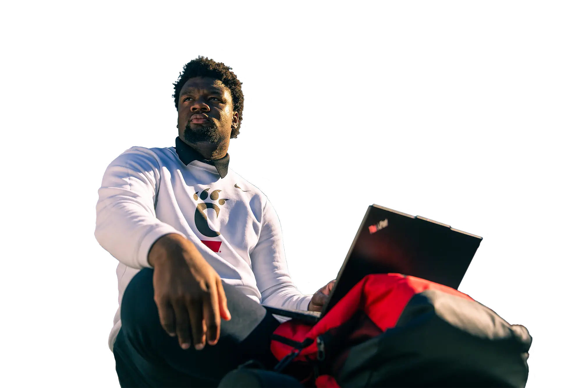 A University of Cincinnati student looks up from his laptop in the bleachers of Nippert Stadium
