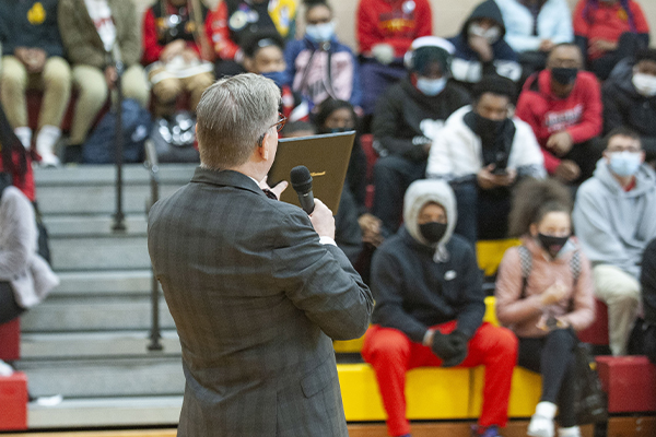 Jack Miner speaking to gymnasium filled with high school students with announcement about Marian Spencer Scholar admittance