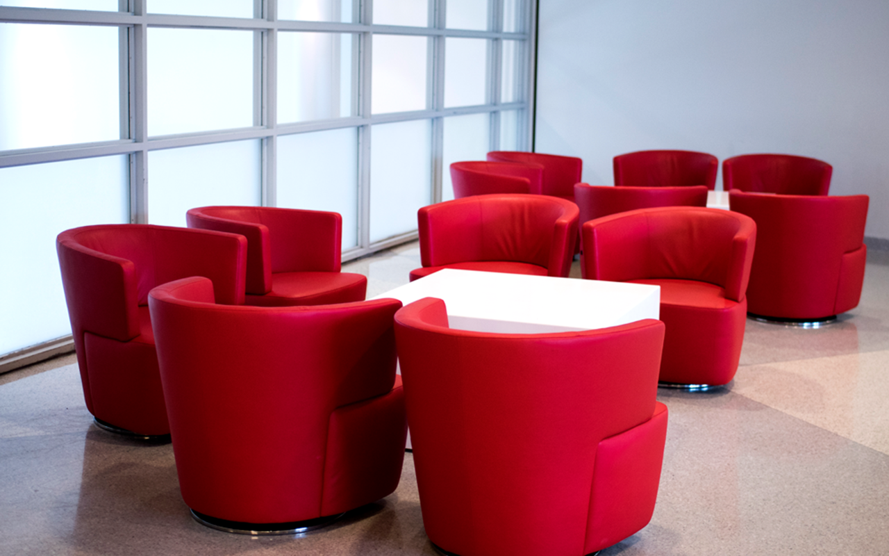 Red cushioned chairs surround two white tables on level 4