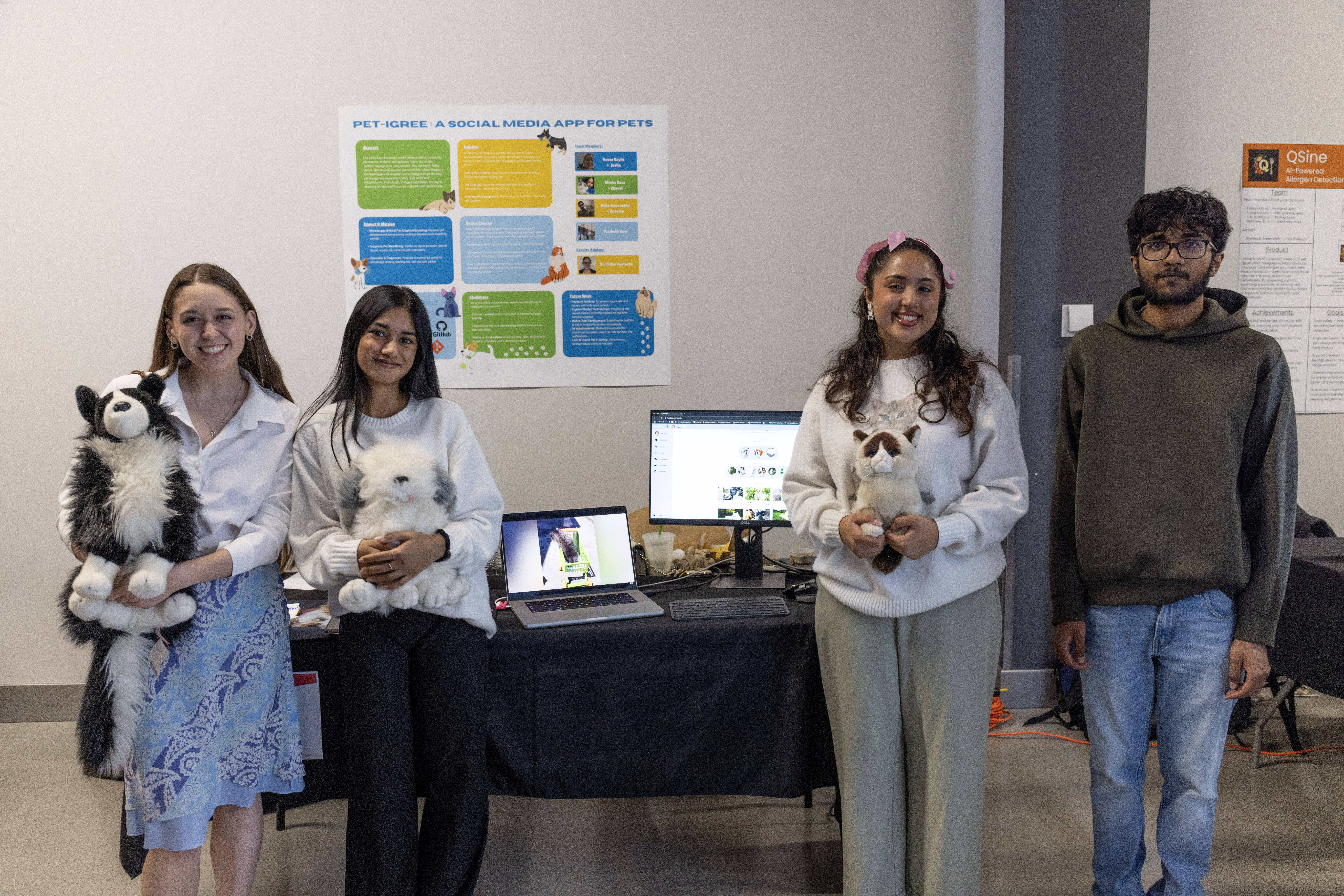 CEAS students stand by their booth at the EXPO and present their pet social media project. They hold stuffed animals. 