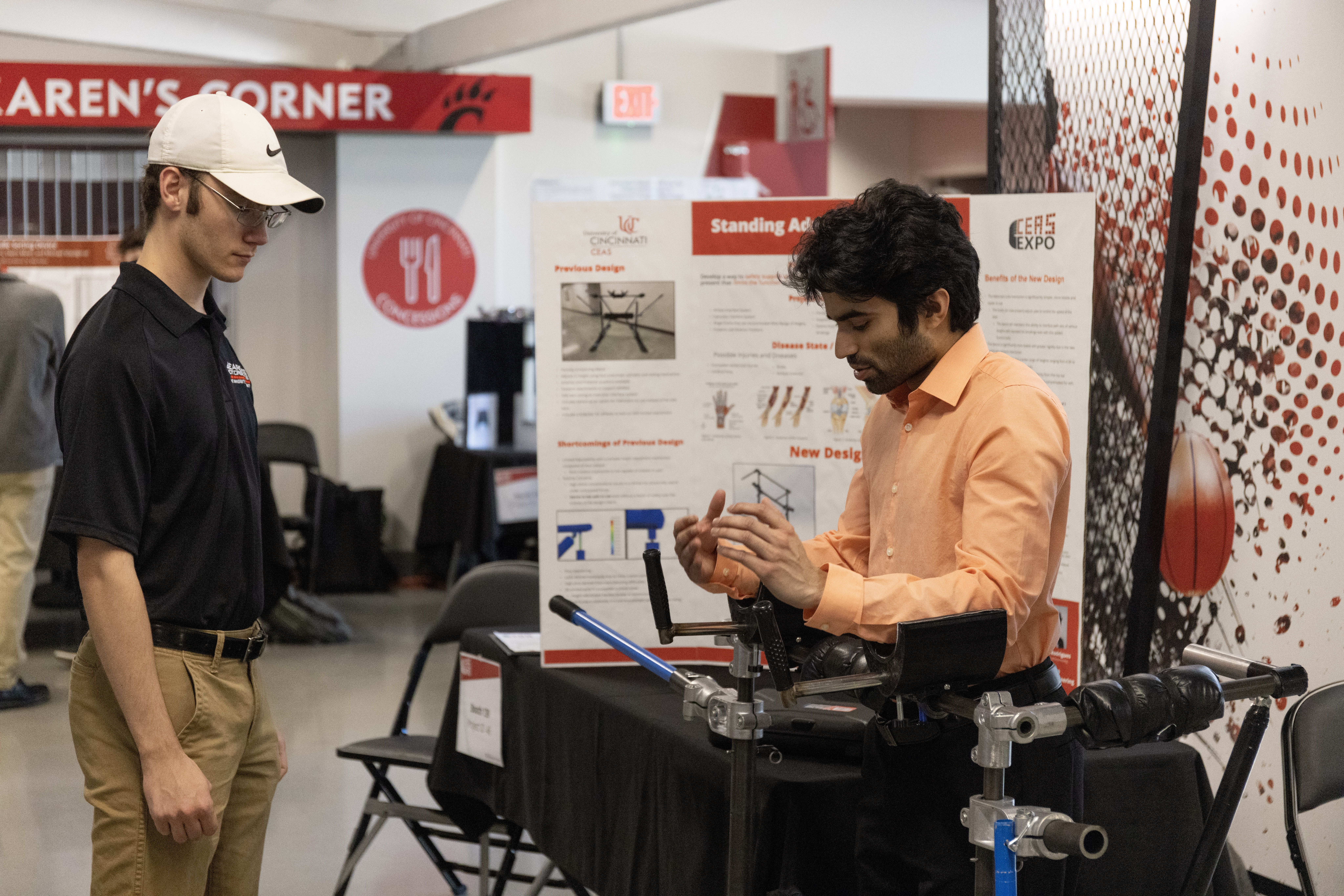 a student stands at his adaptive ski device at the CEAS EXPO and presents the project 