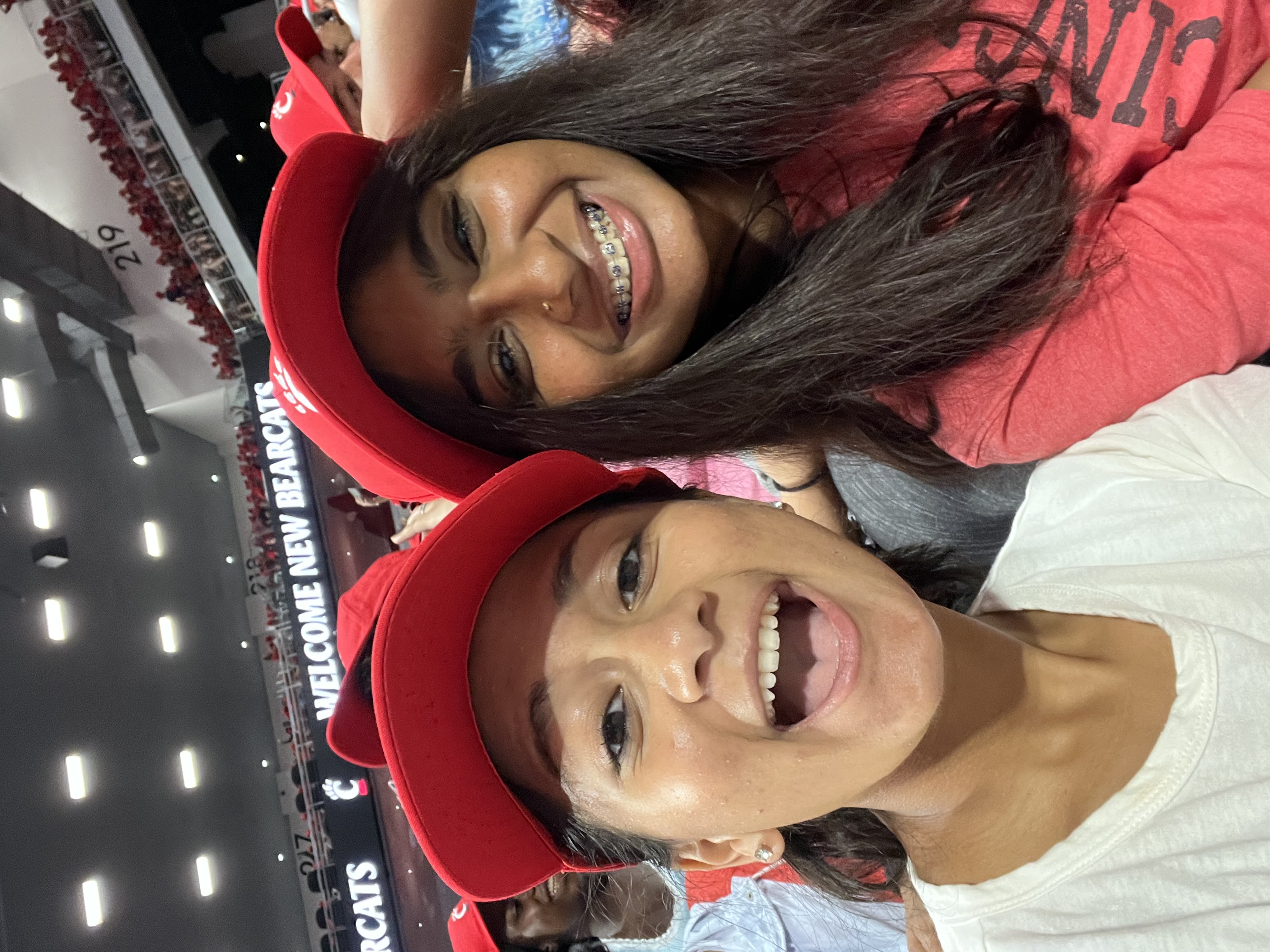 Two girls wearing red baseball caps smile and take a selfie