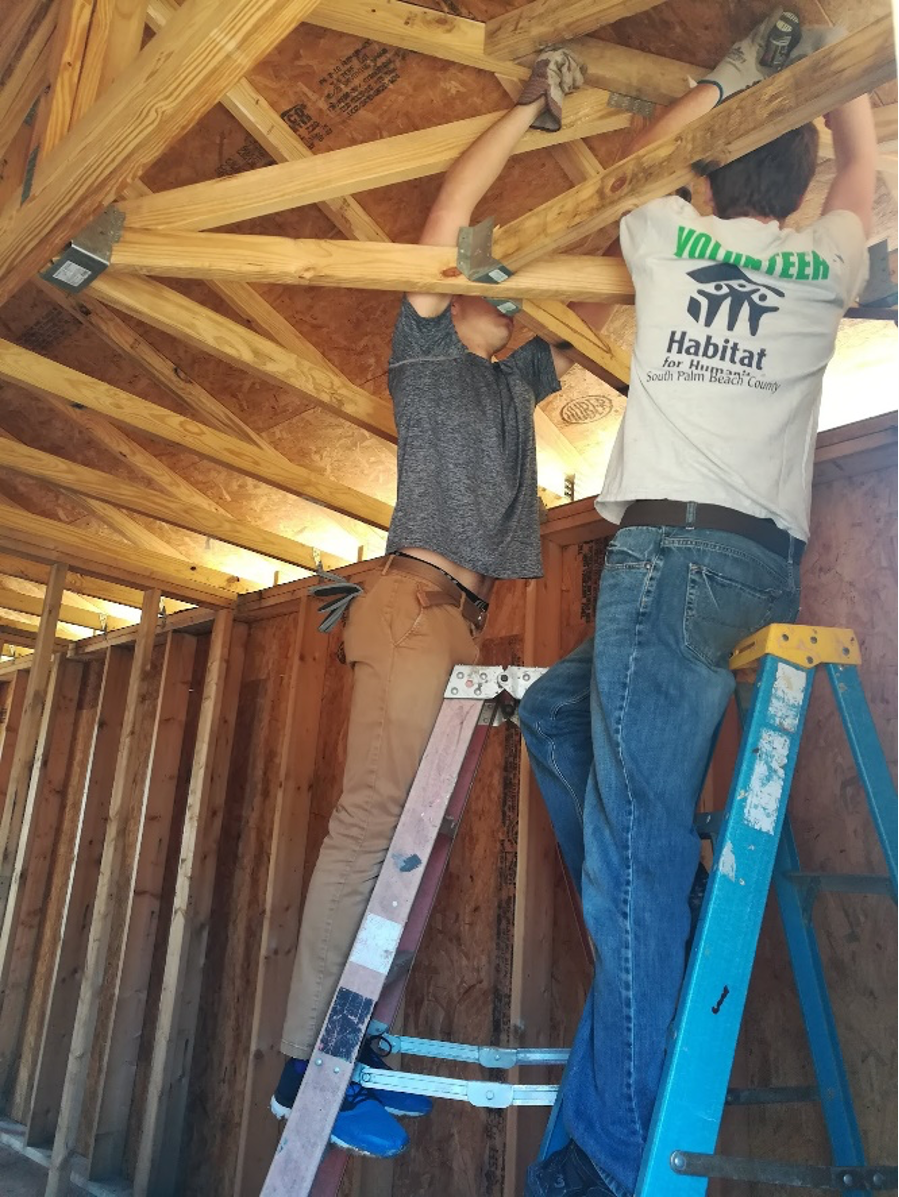 Two students working on a house for habitat for Humanity 