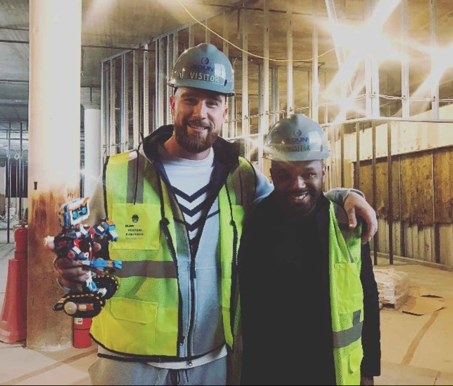 Travis Kelce (left) and André Eanes (right) work at a charity event for Kelce's Catching for a Cause campaign