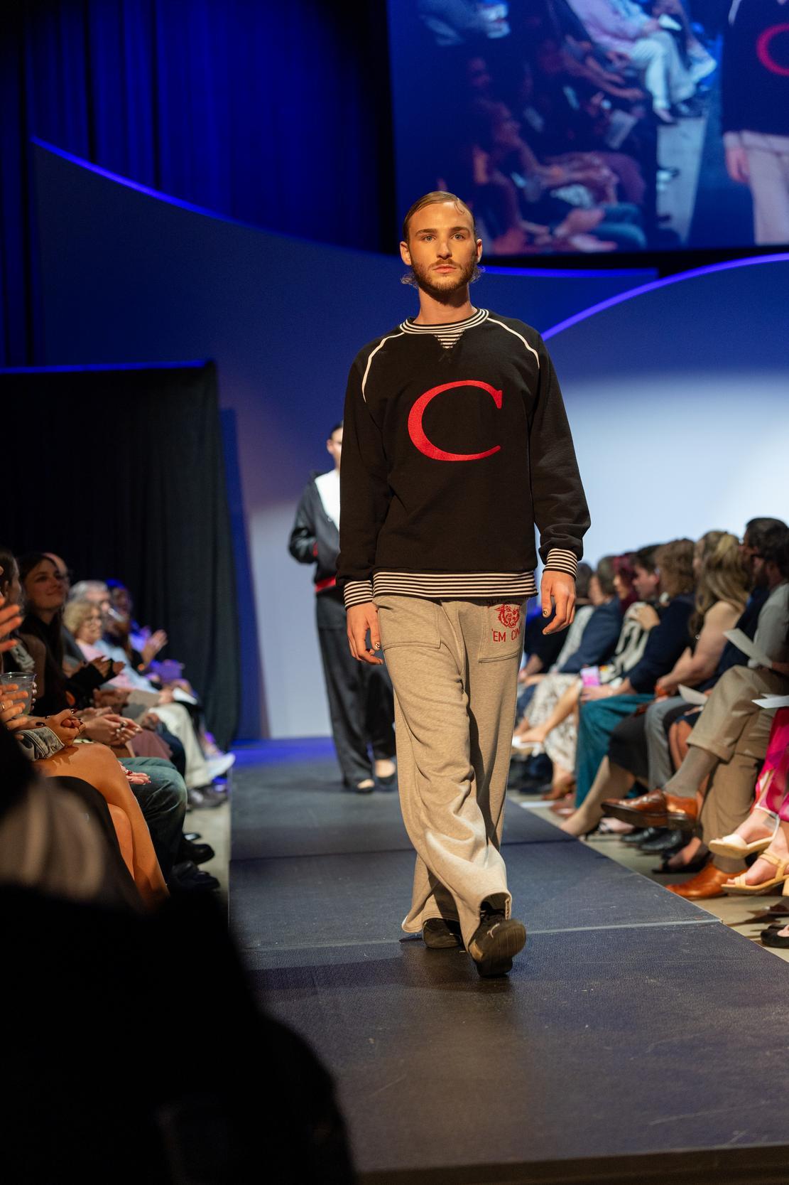 Model wearing a black sweater with the letter C