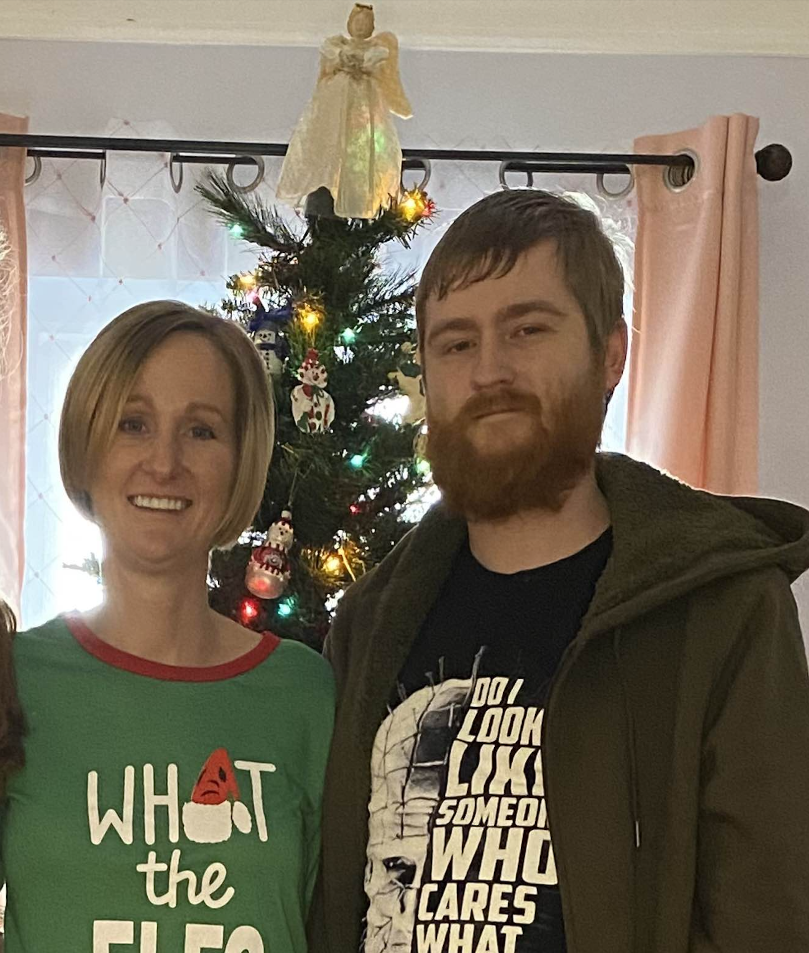 Melissa Lohr and Todd Smith pose in front of a Christmas tree.