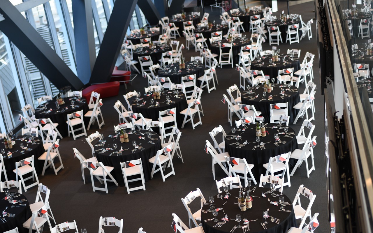 Round tables with chairs around them setup for an event in Nippert Stadium West Pavillion.