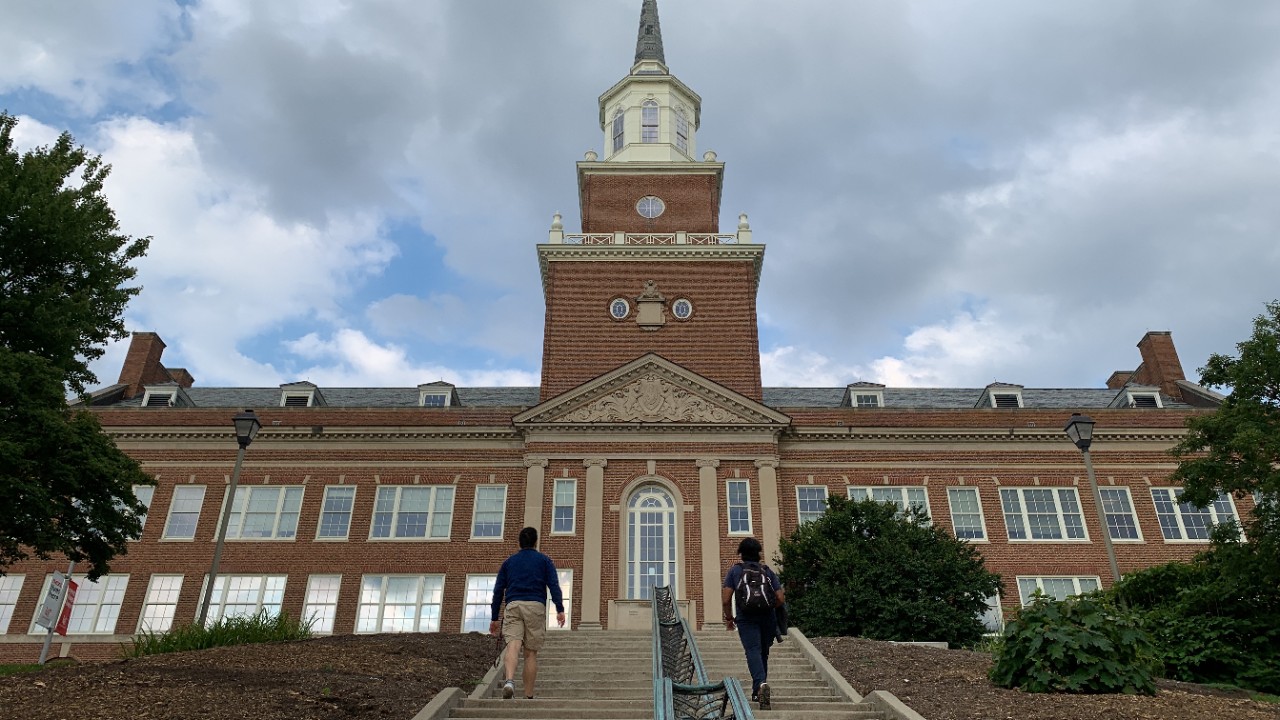 Two international students walk up the steps toward the arts & sciences building.