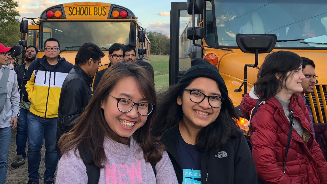 Students gather in front of yellow buses