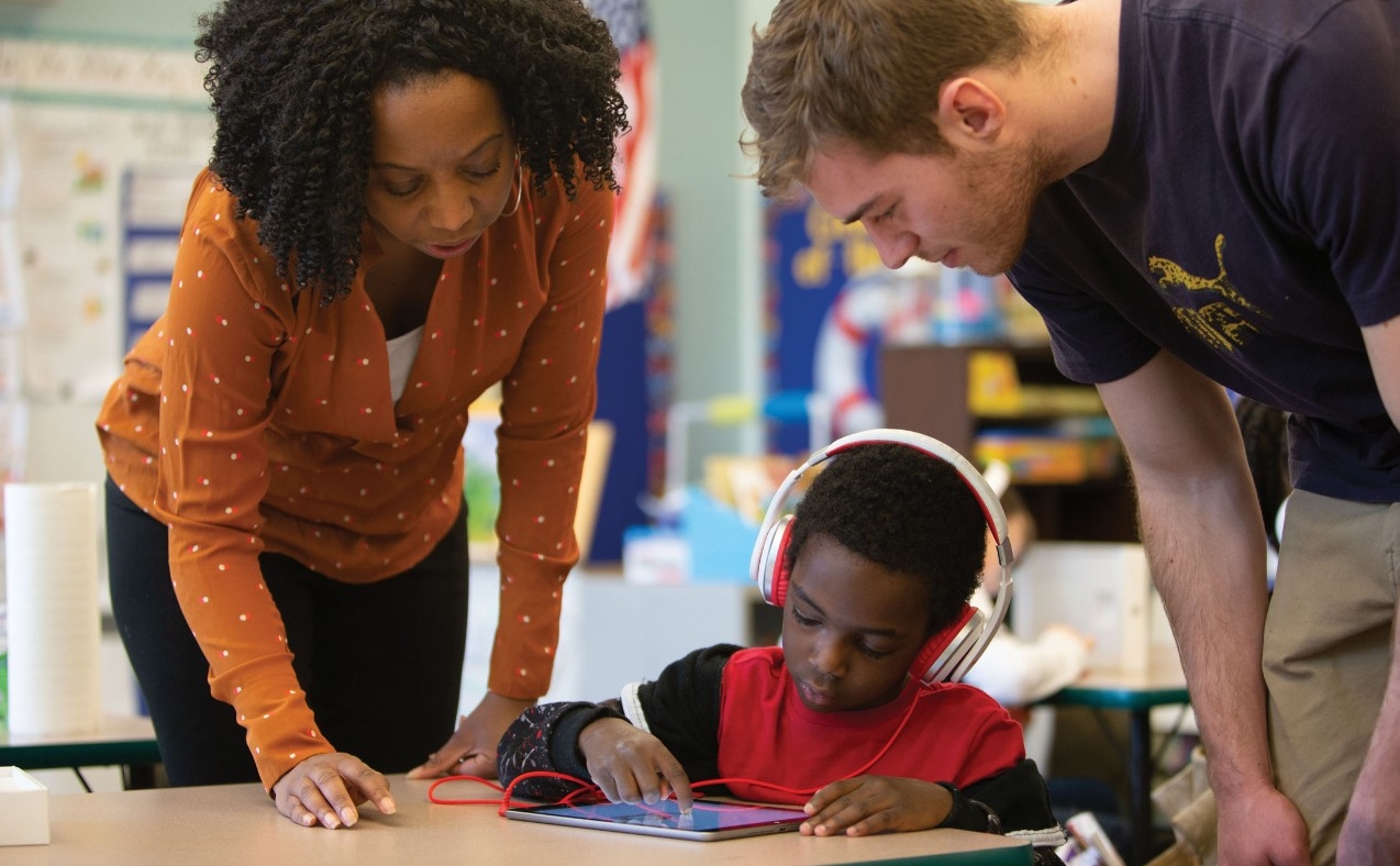 Two teachers assist a young elementary school student