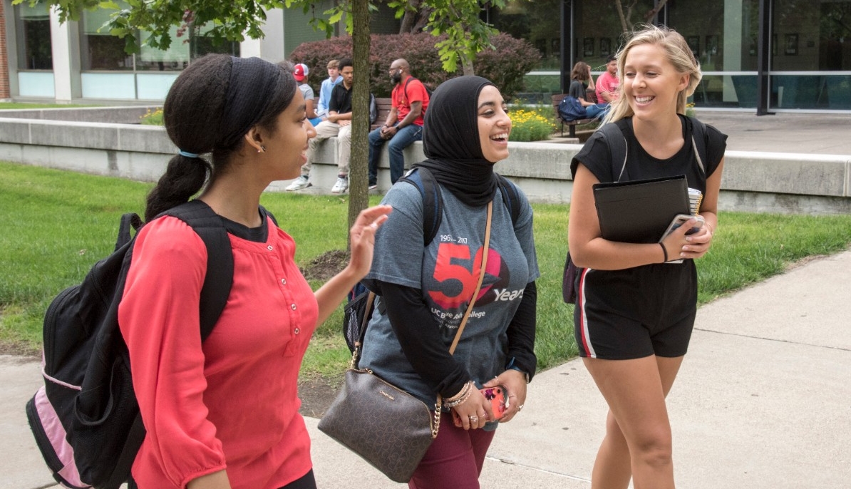 three female students walking on a sidewalk