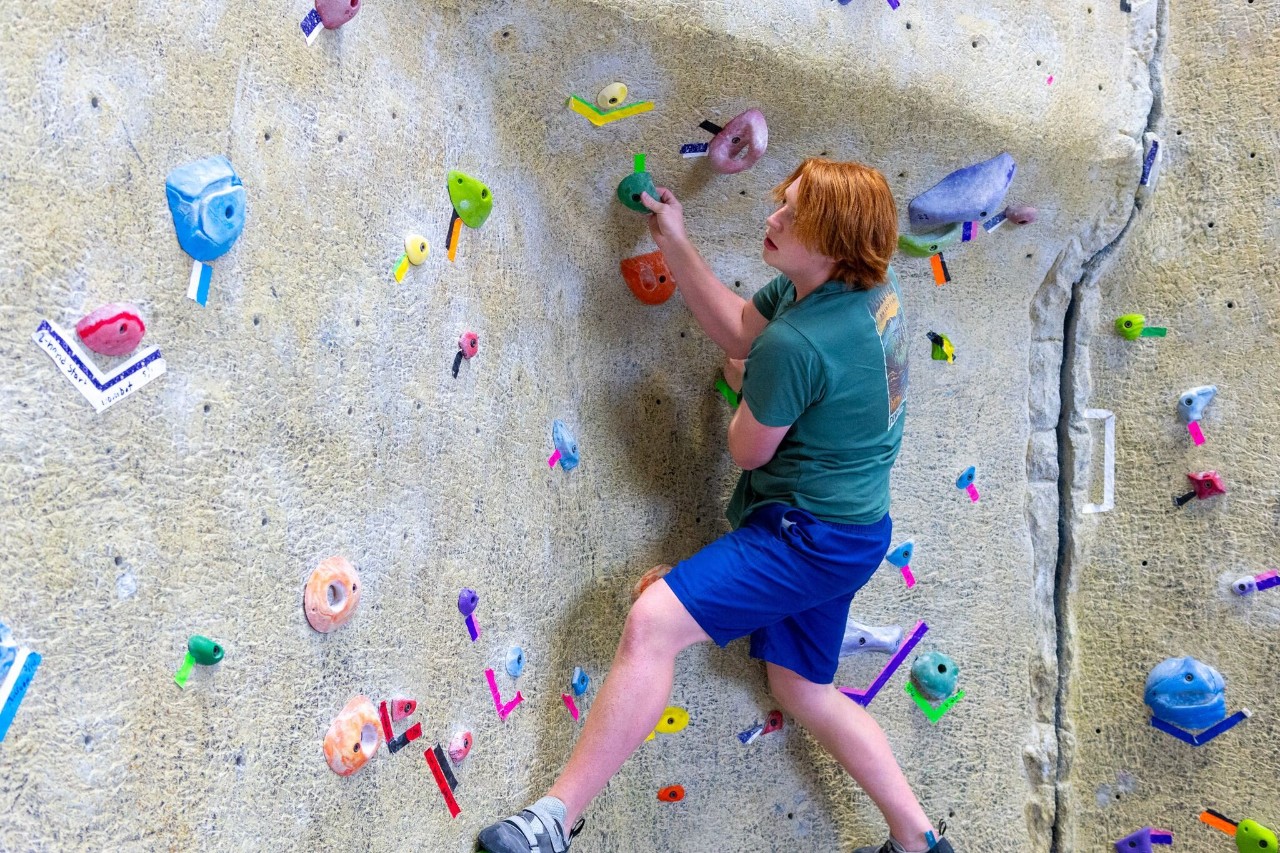 A Campus Recreation guest climbs on the climbing wall. 