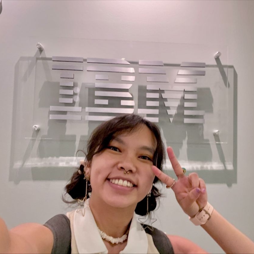 a female student holds up a peace sign while taking a selfie during co-op job. 