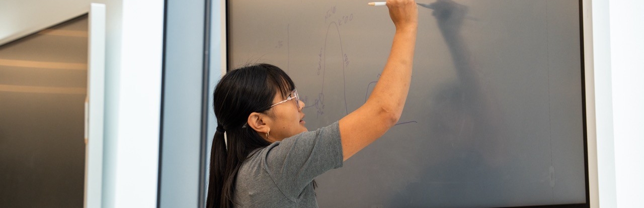 Students writing on the board during a presentation
