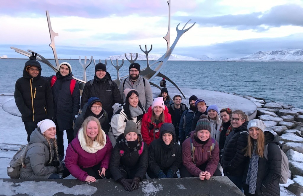 Students pose for a picture by the water in Iceland.