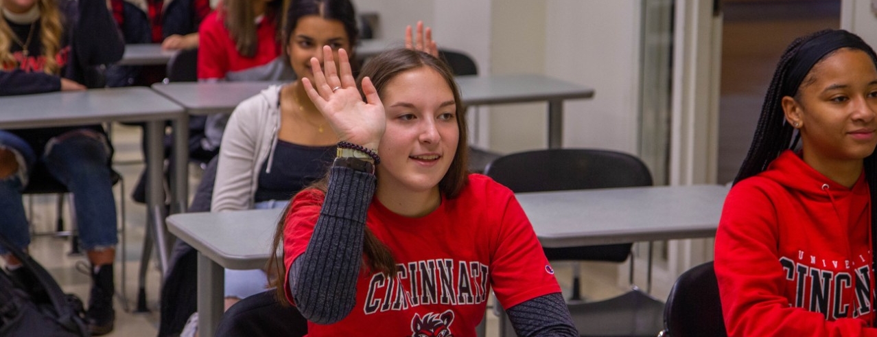 Female student raising hand in classroom