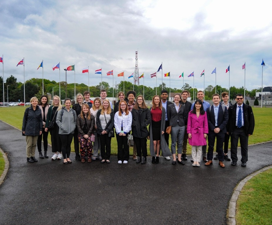 Students standing in front of world flags.