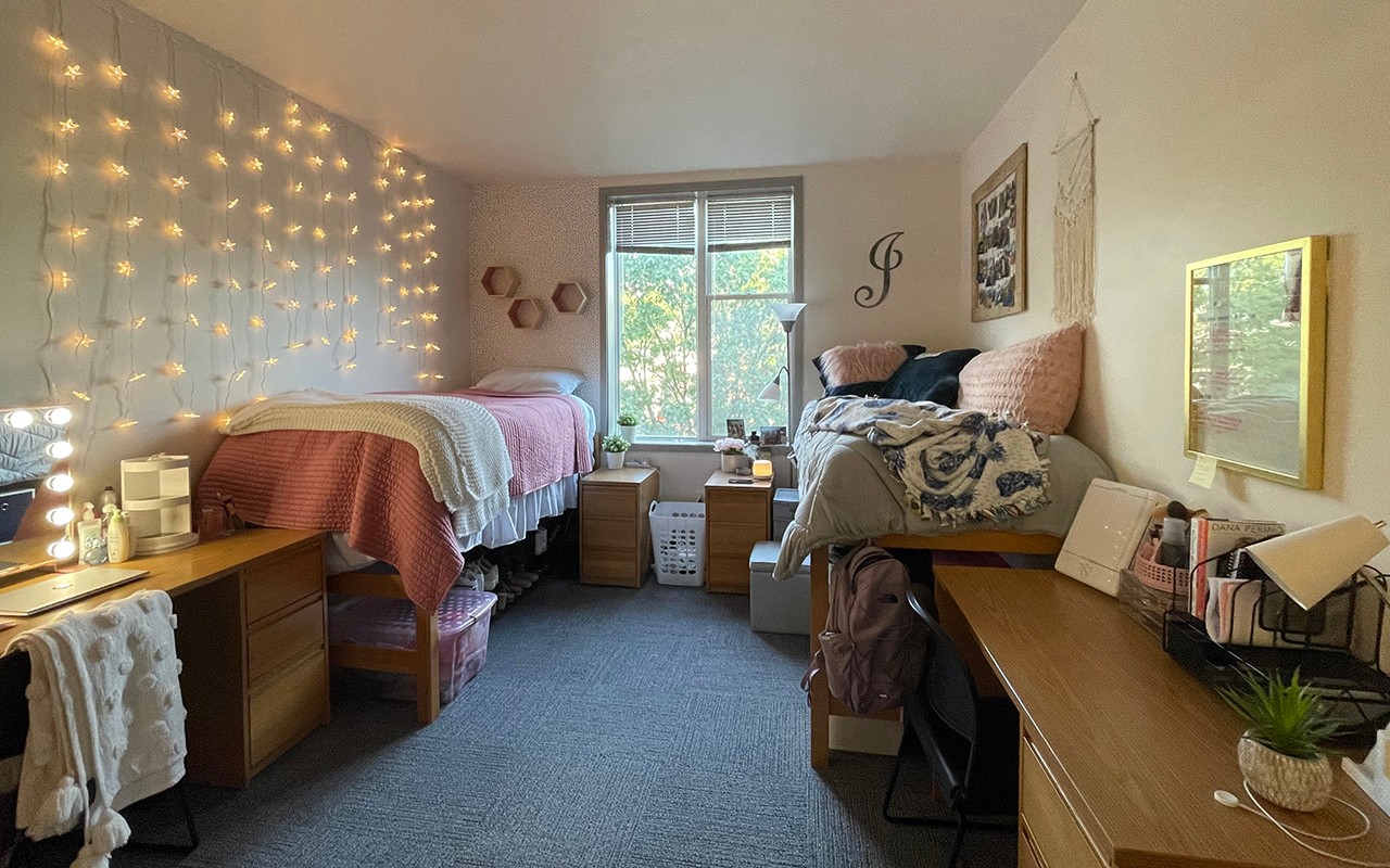 Residence hall bedroom decorated with twinkle lights, and framed art