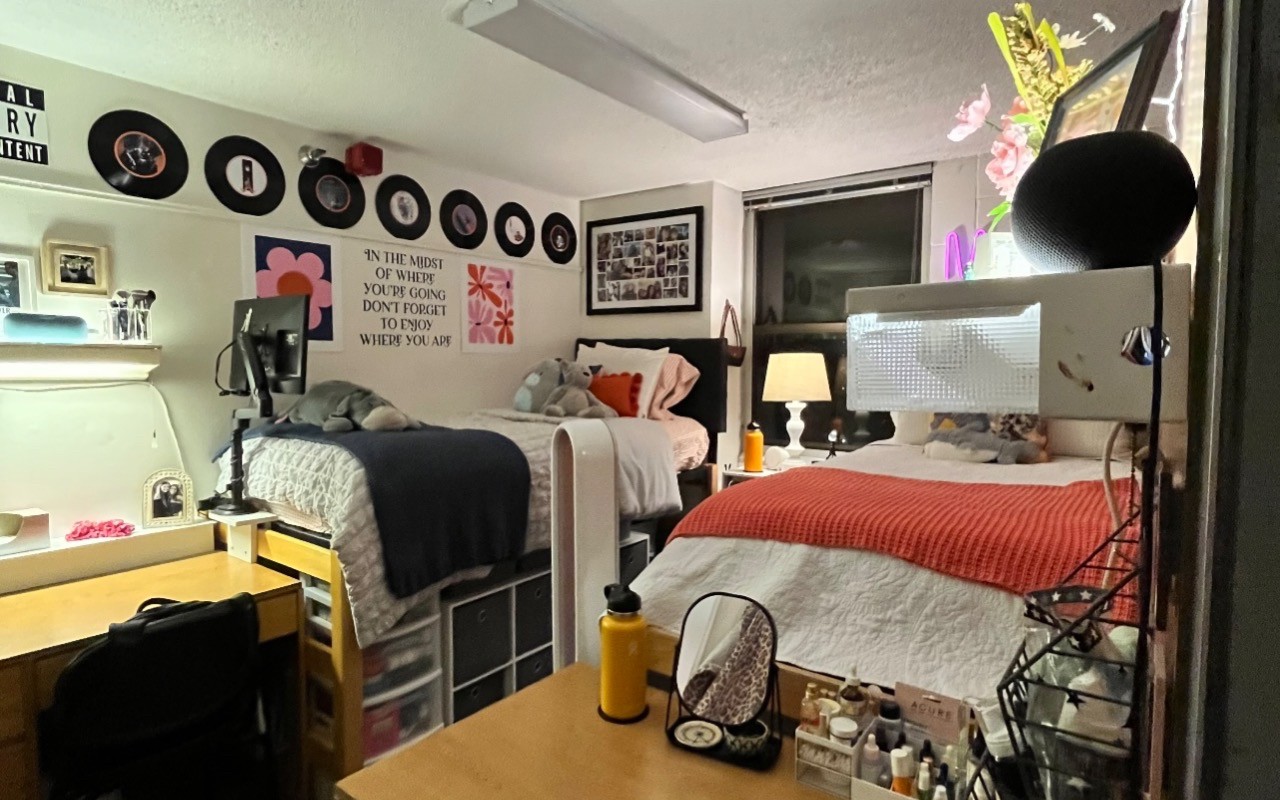 Two beds with white linens, desks and deocrated with graphics and record albums