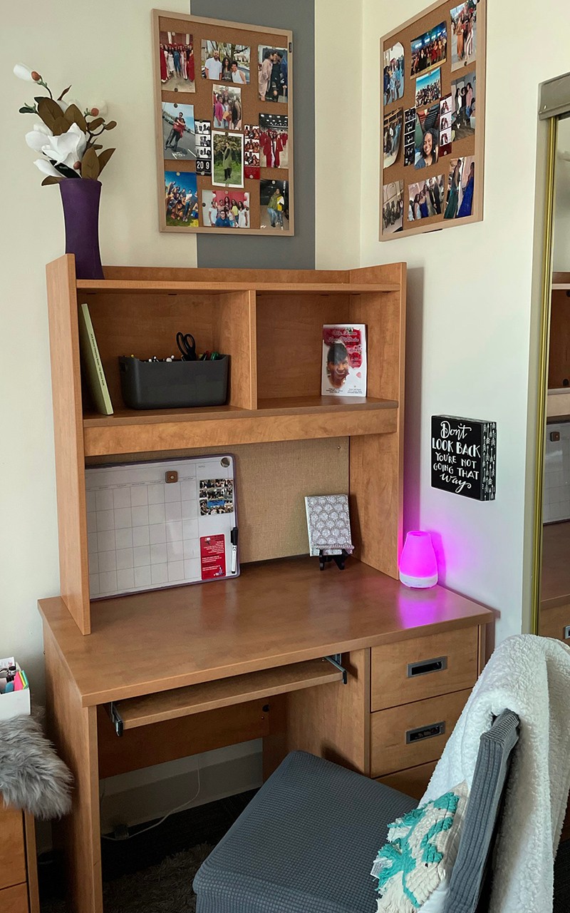 Simply decorated student desk and photo collages above it on walls