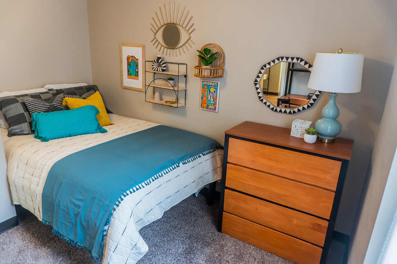 A full-sized bed sits next to a dresser.