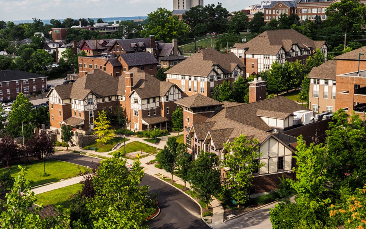 Exterior of Stratford Heights residential complex. There are several Tudor style buildings surrounded by green space and trees.