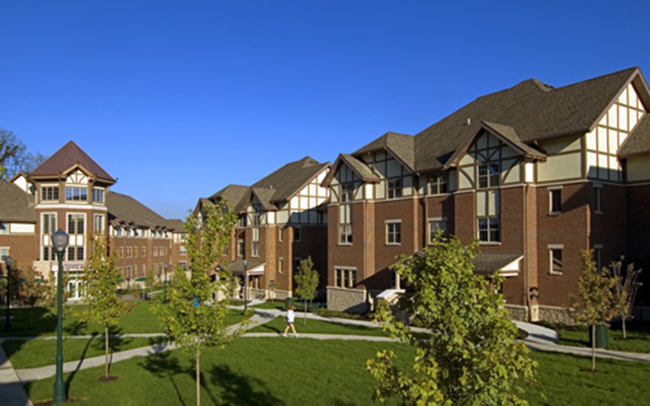 Exterior of Stratford Heights residential complex. There are several Tudor style buildings surrounded by green space and trees.