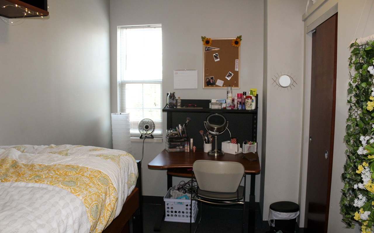 Bed and desk in room of Stratford Hall triple suite