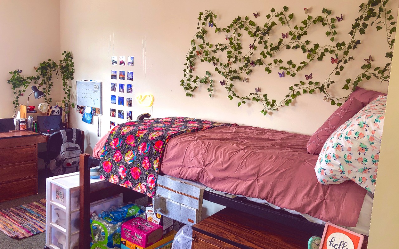 A twin bed sits alongside a decorated wall. 