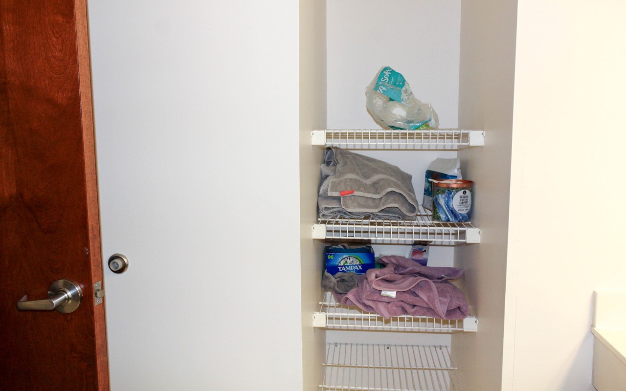 A doorless linen closet in the shared bathroom area of a triple suite in Stratford Heights.