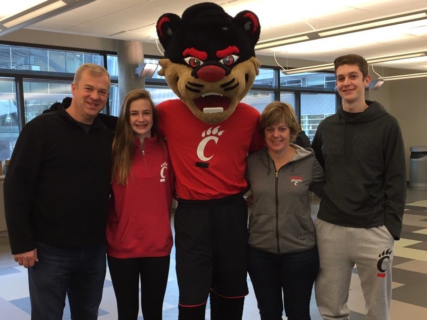 A family poses with their student and the Bearcat mascot