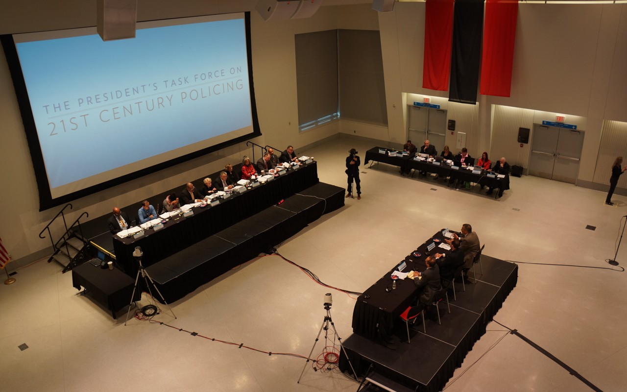 Overhead view of platform with panel discussion, and moderator tables.