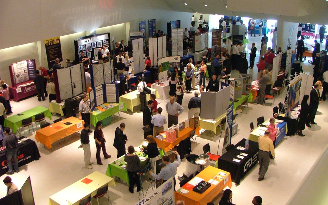 Overhead view of tables and exhibits, with participants at career fair.