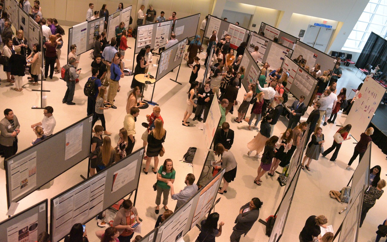 Overhead view of people viewing large exhibits boards