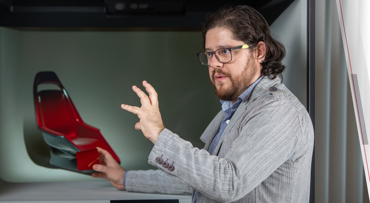 Professor speaks in front of a car seat model