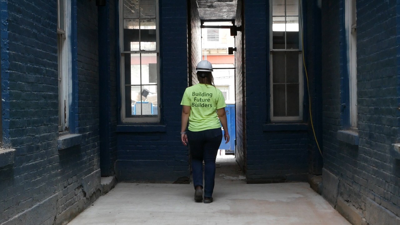 wide shot Swisher with back toward camera on job site in the interior of a historical building.