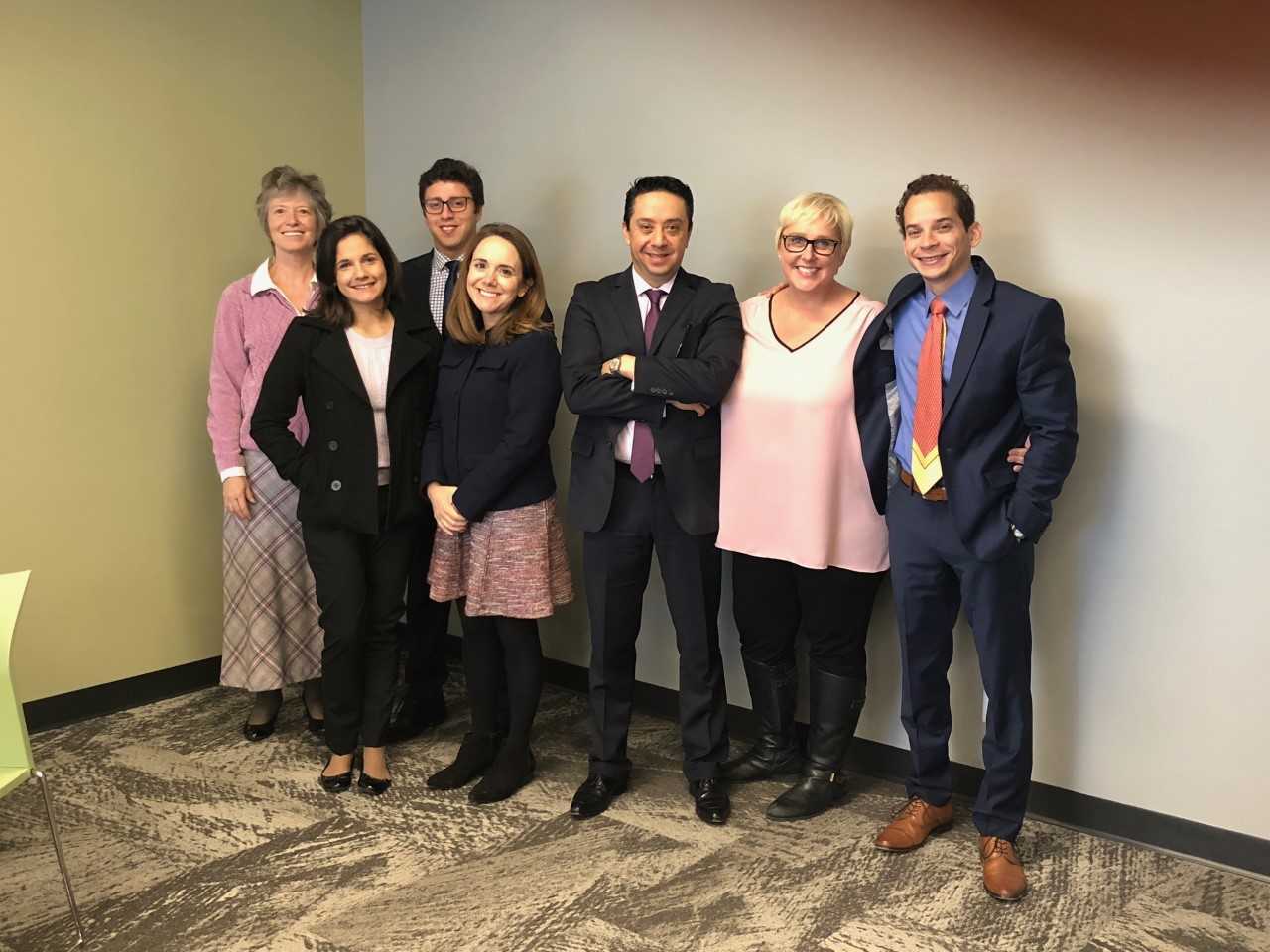 Speakers smiling during event. 