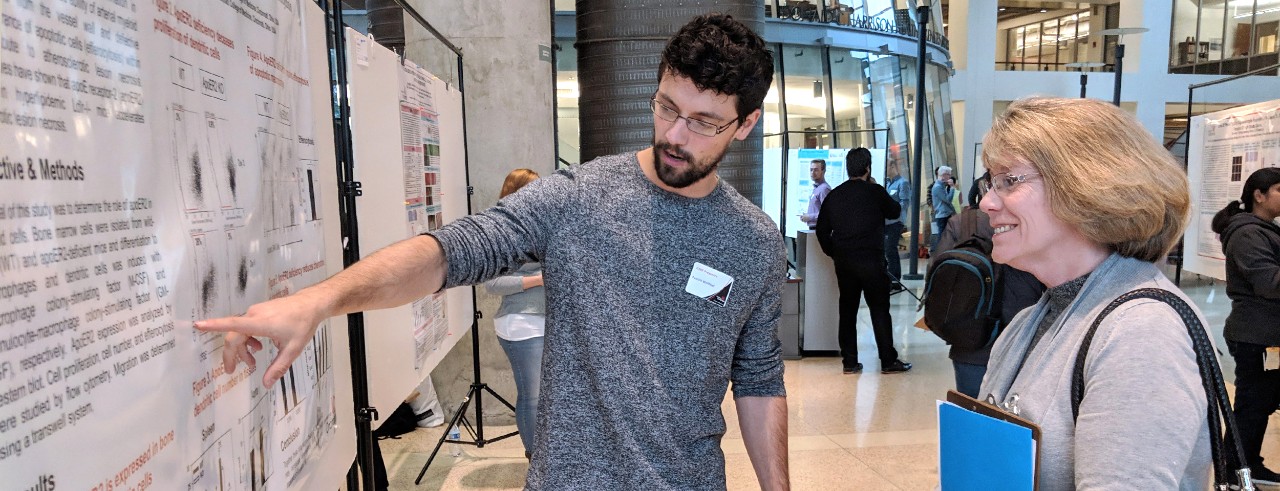 Graduate student presents research poster in the College of Medicine.