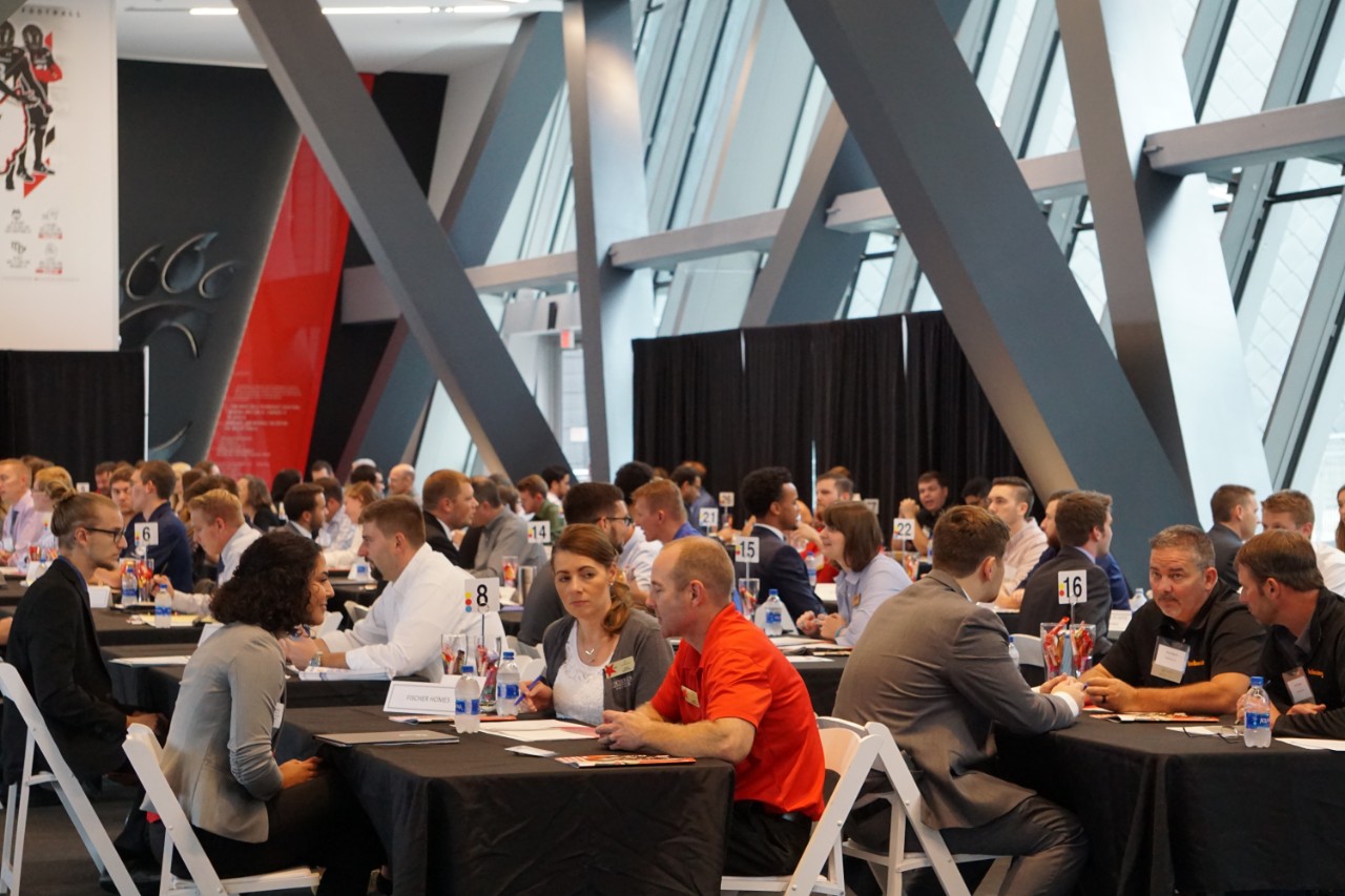 students and industry reps talk at tables