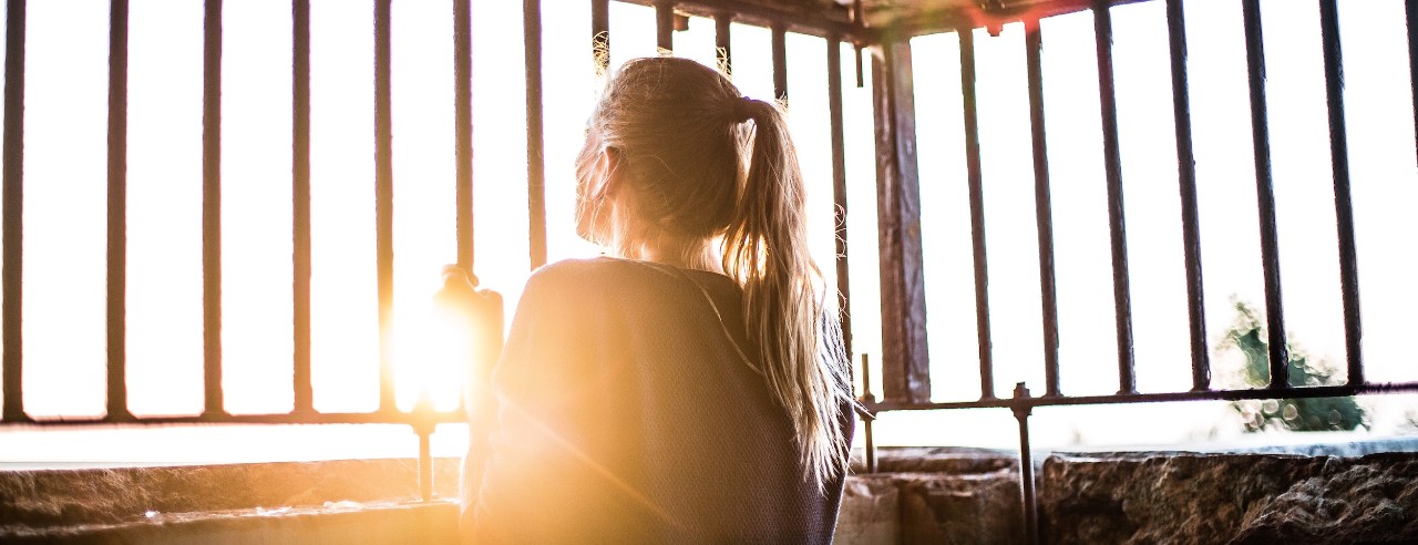 A woman enclosed by iron bars
