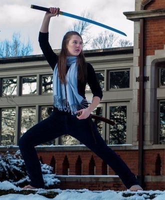 Laura Stegner raises her weapon during a martial arts pose as president of UC's club taekwondo team.