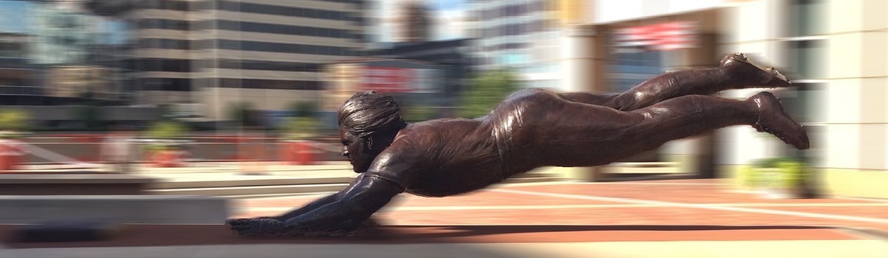 A bronze sculpture of a baseball player sliding head-first. 