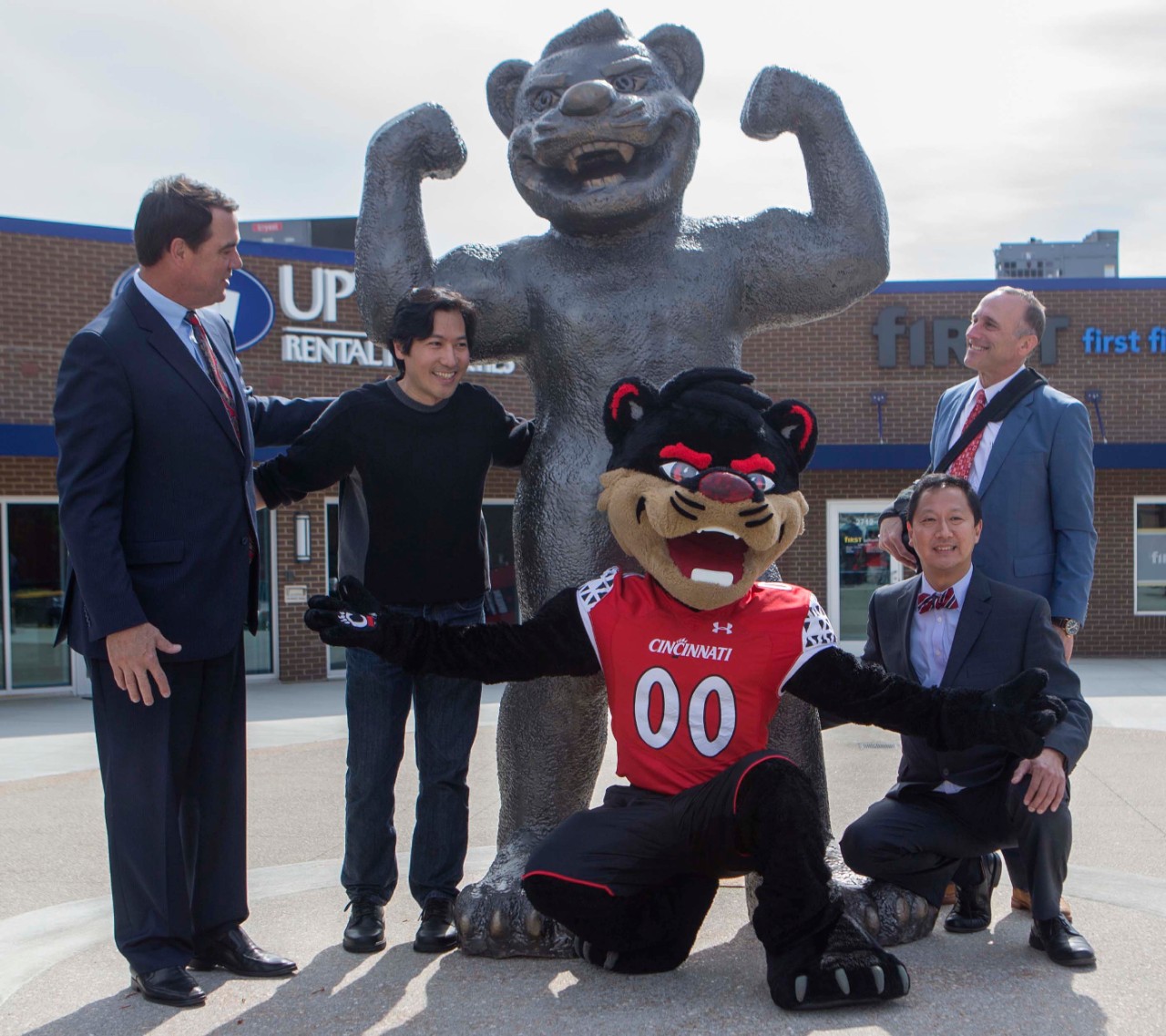 Left to right UC AD Mike Bohn, local artist Tom Tsuchiya, Bearcat mascot, UC President Dr. Santa Ono and Uptown CEO Dan Schimberg pose with the new Bearcat statue on Short Vine Street. UC/Joseph Fuqua II