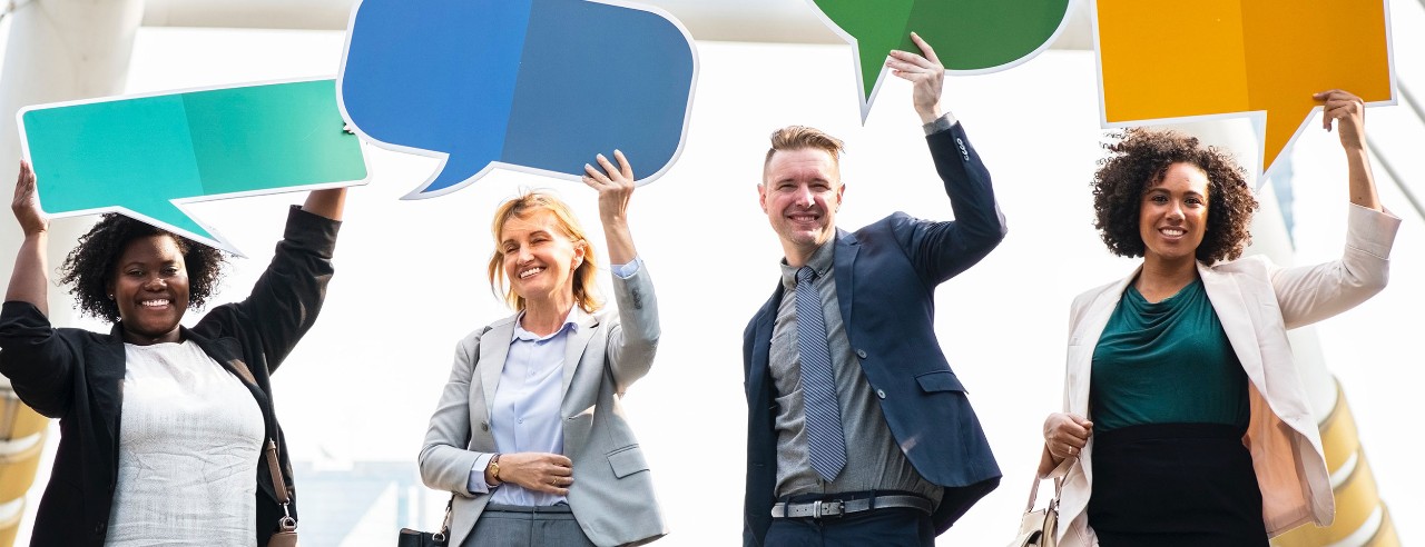 people holding cardboard cutouts of speech bubbles