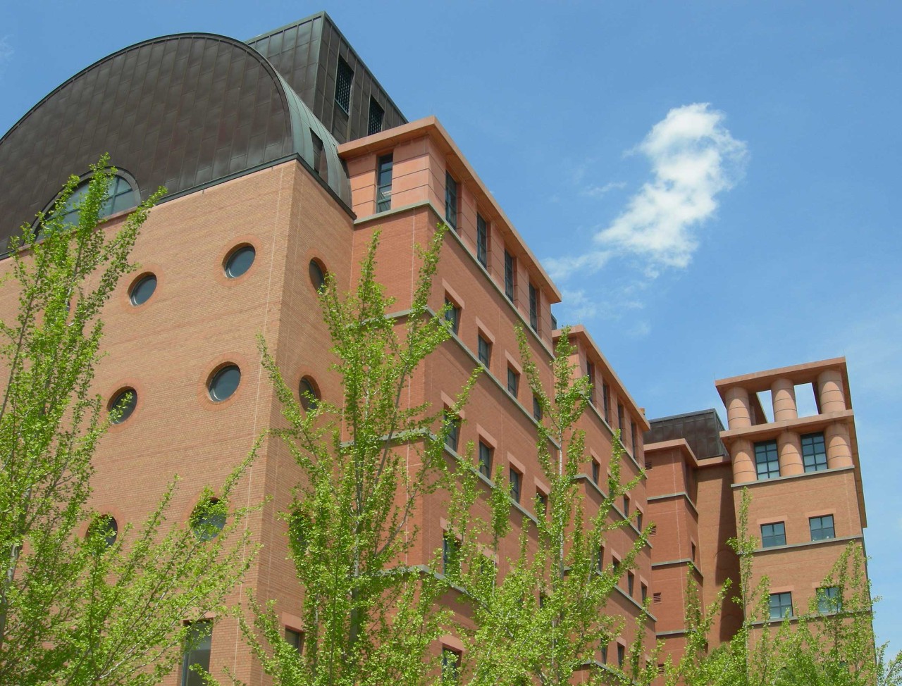 a shot looking up at the side of the engineering research center, green trees in foreground