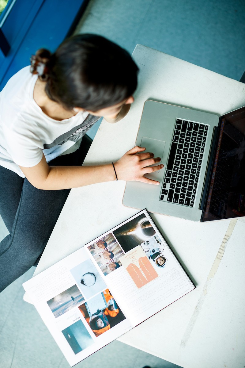 woman at computer with book