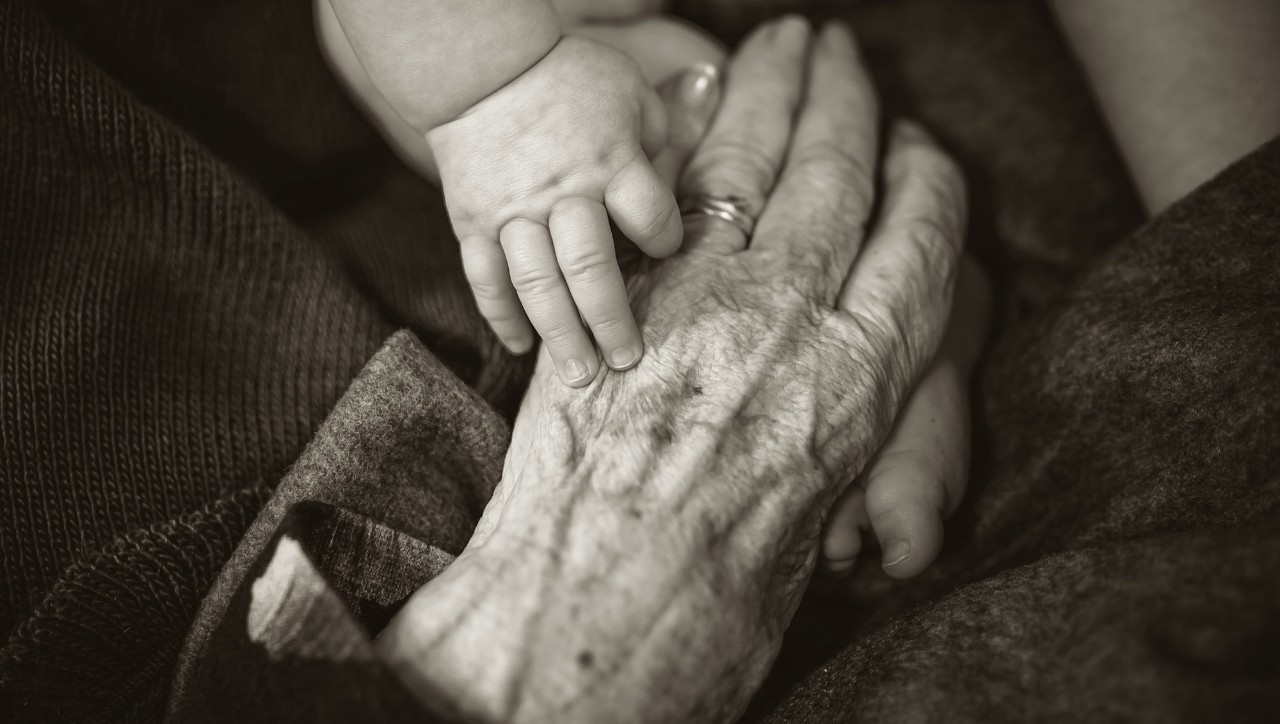 A young and older hand embrace
